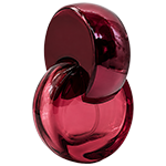 Red circular glass spray bottles featuring distinctive plastic semi circular arched loop cap that curve over the spray nozzles, with gold sprayer.